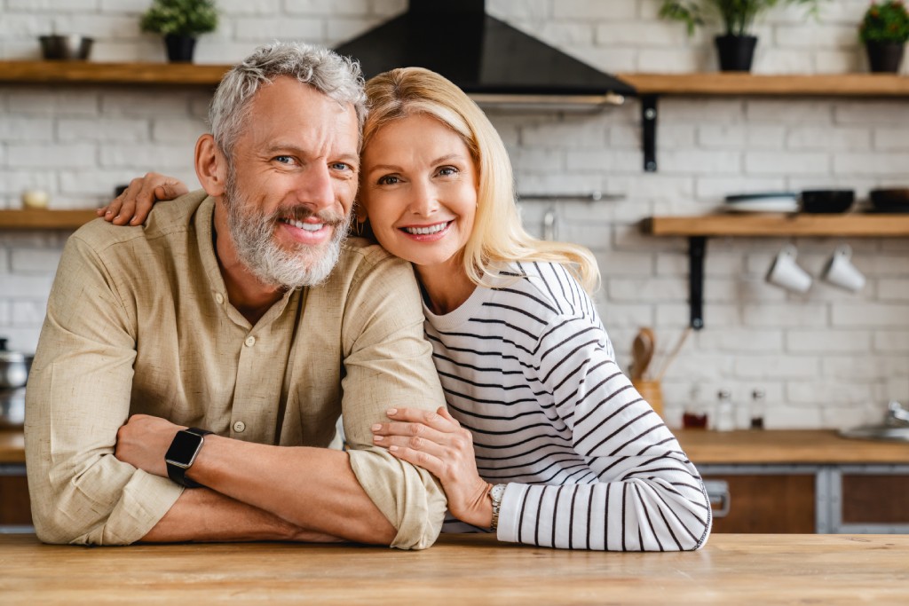 Middle-aged couple hugging in their kitchen