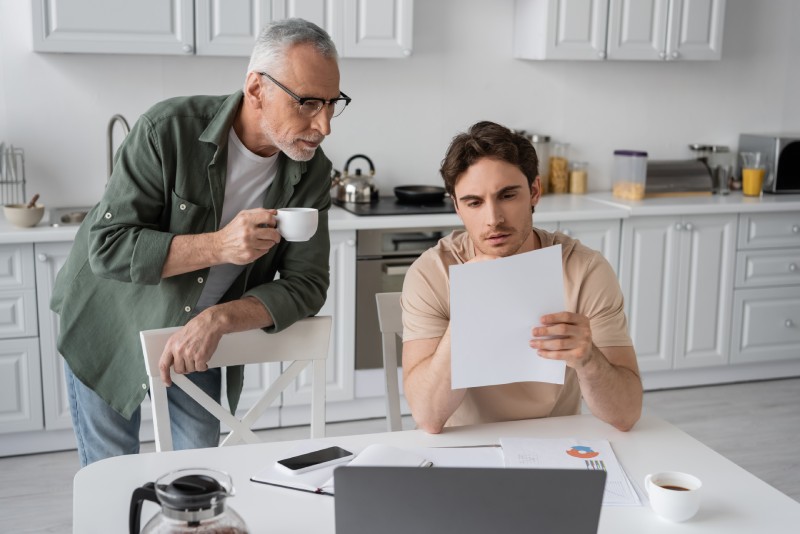 Young man and father looking at banking options.