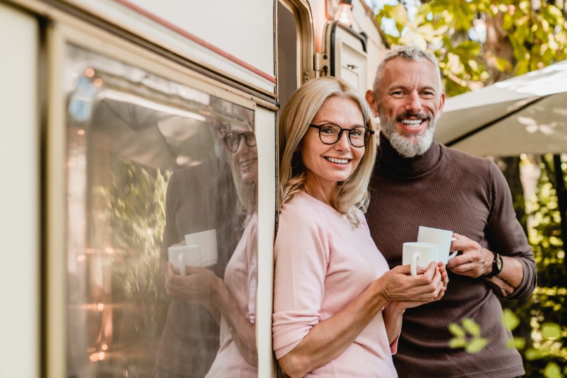 A couple enjoy coffee outside their RV