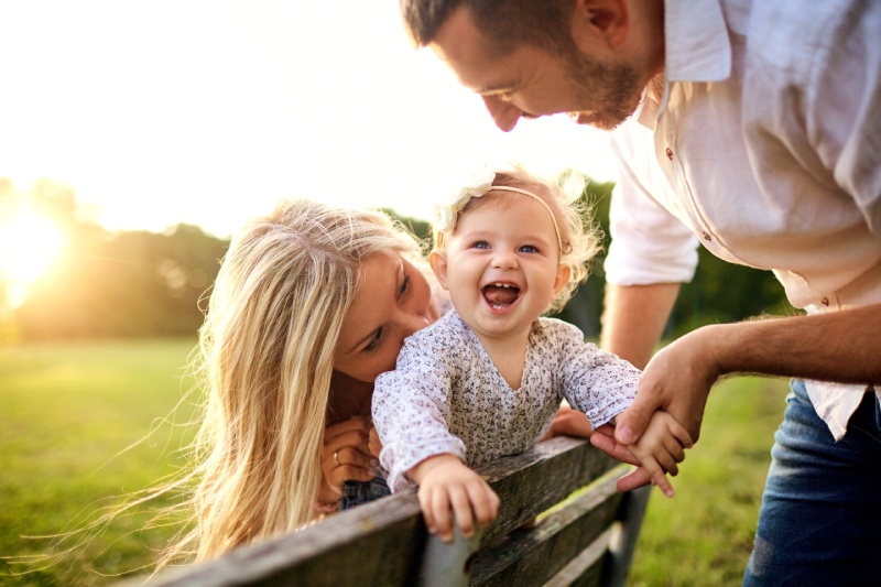 Parents spend time in a park with their toddler daughter