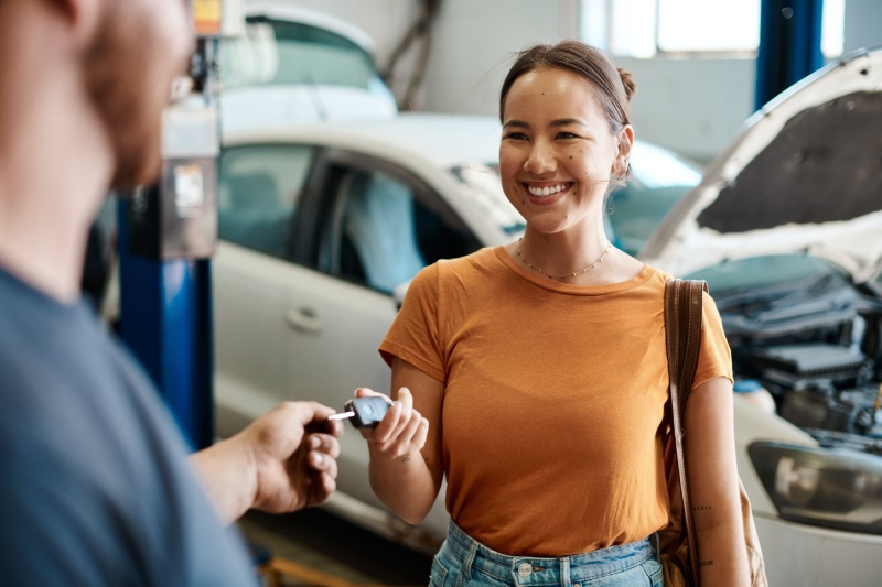 A woman receives her keys after bringing her car into a workshop for repairs