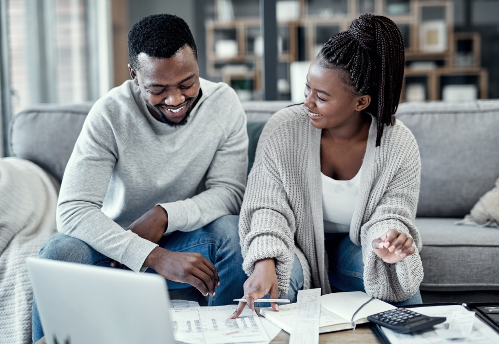 Happy couple reviewing their finances together at home.